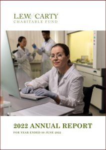 Cover page of the LEW Carty Annual Report with a female scientist typing and looking at the camera